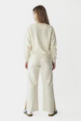 Pantalón negro de tiro alto, con tajo en el costado y pierna ancha.