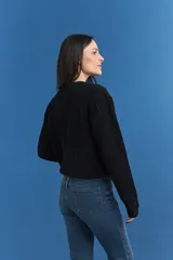 Sweater de punto con textura tipo waffle, color blanco, de corte clásico con cuello redondo y mangas largas.