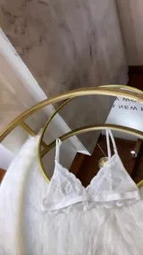 Bralette de diseño triangular confeccionado en microtul transparente y encaje con terminaciones festoneadas. Cuenta con breteles regulables y banda elástica inferior.