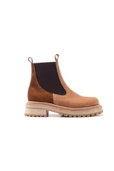 Botas tipo Chelsea con paneles elásticos laterales, confeccionadas en una combinación de cuero liso y gamuza en tonos marrones. Presentan una suela track robusta y dentada en color beige.