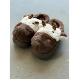 Pantuflas de peluche con diseño de vaca, confeccionadas en piel sintética suave. Cuentan con suela de goma antideslizante y diseño abierto en el talón.