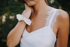 Pijama de satén elastizado color blanco, compuesto por un top con escote en V y puntilla en los breteles, y un short con elástico en la cintura y detalle de puntilla en los costados.