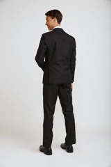 Traje de tres piezas compuesto por saco, chaleco y pantalón de vestir en color negro. El saco presenta solapas clásicas y cierre de botones, el chaleco cuenta con cierre frontal de botones y el pantalón es de corte recto y formal.