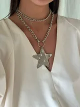 Collar doble con cadena de eslabones plateada, uno corto y otro largo con dije de estrella transparente con estampado de fantasmas.