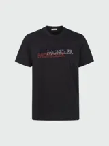 Remera de algodón negra con cuello redondo y mangas cortas. Presenta un estampado frontal con el logo de la marca en capas superpuestas en colores azul, blanco y rojo.