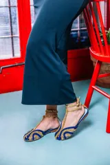 Sandalias tipo cangrejeras con rejilla en la punta y laterales combinados en ante morado y glitter dorado. Ajuste con hebilla en el tobillo. Fabricadas en España con interior de piel y suela de cuero. Cuentan con una cuña interna de 1,5 cm.