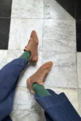 Championes de estilo urbano confeccionados en una combinación de cuero texturizado y gamuza en tonos marrones, con suela plana y diseño minimalista.
