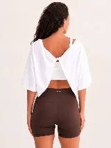 Remera de algodón con diseño de espalda abierta y detalle de nudo torzado. Presenta un corte holgado y mangas cortas, ideal para actividades deportivas o uso casual.