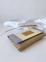 Billetera de cuero color crema, lila y beige con cierre de broche y monedero externo.