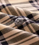Camisa masculina de algodón con diseño a cuadros, corte oversized, cuello camisero, bolsillos frontales con solapa, cierre de botones y estampa en las mangas.
