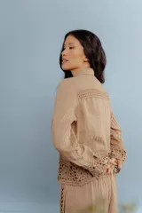 Camisa de lino blanca con detalles de encaje crochet en los puños y en el ruedo. Presenta un diseño romántico con cierre frontal de botones.