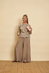 Pantalón evasé de lino color marrón, súper amplio, con cintura con puño y bolsillos laterales.