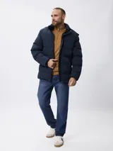 Campera de nylon acolchada en color azul marino, con cierre frontal y botones a presión, bolsillos laterales y capucha desmontable.