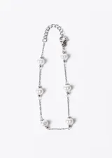 Pulsera plateada con perlas blancas y cierre de mosquetón.