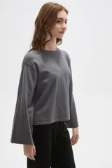 Remera de manga larga confeccionada en viscosa, con cuello redondo a la base y diseño holgado.