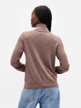 Buzo de punto con cuello alto tipo polera, de corte ajustado y manga larga.