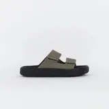 Sandalia tipo 'slide' de dos tiras ajustables con velcro, color verde oliva, sobre una plataforma gruesa de goma negra con relieve.