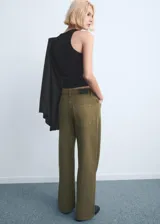 Jeans de corte recto y tiro medio color verde militar, confeccionados en 100% algodón, con diseño clásico de cinco bolsillos y cierre frontal con botón y cremallera.