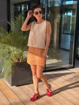 Pollera corta de cuero ovino color suela, con diseño de paneles y costuras visibles, cierre frontal y bolsillos laterales.