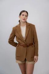 Blazer color camel de baby alpaca, con cuello de solapa, cierre frontal con botones y bolsillos laterales.