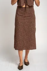 Falda midi de corte recto, color marrón con estampado de lunares pequeños en tono claro. Presenta un diseño de tiro alto y largo hasta la pantorrilla.
