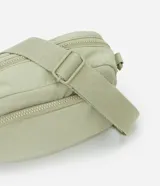 Bolso bandolera de estilo deportivo en color verde claro, confeccionado en poliéster. Cuenta con cierre principal de cremallera, bolsillo frontal con cierre, bolsillo trasero con cierre a presión, asa larga desmontable y regulable, y logo de la marca en relieve en la parte frontal.