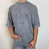 Remera oversize de algodón pesado con efecto de lavado snow wash, cuello redondo, mangas cortas con costuras vistas y corte amplio.