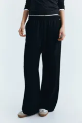 Pantalón negro de corte ancho, con cintura elástica y bolsillos laterales.