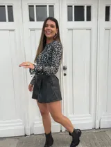 Short negro de cuerina con pinzas delanteras y cierre con botón.