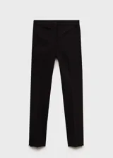Pantalón negro de corte ajustado y tiro medio, con bolsillos laterales y cierre frontal con cremallera y botón.