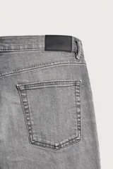 Jeans slim fit de color negro para hombre, con tiro medio, diseño de cinco bolsillos y cierre frontal con cremallera y botón.
