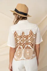 Camisa color marfil de algodón con calado bordado color camel, de corte crop y mangas cortas.