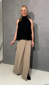 Falda larga beige de corte recto con tajo lateral, confeccionada en viscosa y elastano, con pretina lisa al frente y elástico en la parte posterior.