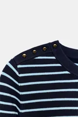 Jersey negro de punto de manga corta y cuello redondo, con detalle de botones dorados en el hombro.
