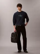 Mochila Calvin Klein de poliuretano color negro, de diseño minimalista con silueta redondeada. Cuenta con un compartimento principal con cierre, bolsillo frontal externo con cierre y el monograma CK grabado. Incluye asa superior y correas acolchadas ajustables.
