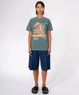 Remera de algodón color verde azulado con lavado especial, cuello redondo y manga corta. Estampado frontal con temática de rock and roll, que incluye un músico tocando un instrumento, una guitarra eléctrica y el texto "ROCK & ROLL MARATHON 1980".