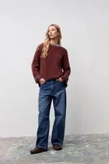 Pullover de punto acanalado en color marrón, con corte oversize, cuello redondo y detalles en contraste en el cuello y los puños.