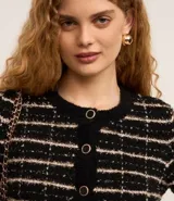 Cardigan cropped negro con diseño de tweed a cuadros blancos, con cuello redondo y cierre frontal con botones esmaltados.