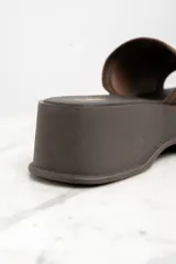 Zueco con plataforma color marrón, capellada de gamuza y plantilla con la inscripción "Lemon".