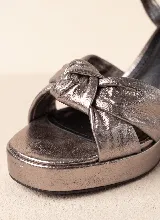 Sandalia de taco alto ancho con plataforma delantera y diseño elegante y sofisticado. Presenta una capellada con tiras anchas y detalle de nudo central. Incorpora pulsera ajustable con hebilla en el tobillo.