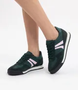 Championes de estilo vintage para mujer, modelo chutera, en color verde oscuro con detalles en rosado y blanco. Presentan suela dentada negra, puntera redondeada y cordones a tono.