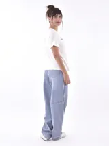 Remera de manga corta color beige, con cuello redondo y un bordado en el pecho que dice "bloom with grace" en hilo blanco y un pequeño detalle naranja.