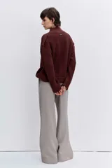 Cardigan de punto acanalado en color bordó, con cuello polo y cierre frontal de botones. Presenta un diseño de hombros caídos y mangas largas con puños ajustados.