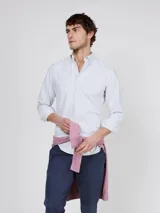 Camisa Oxford de corte regular fit, color blanco con finas rayas verticales, cuello buttondown y manga larga con puño simple. Cuenta con cierre frontal de botones y logo bordado en el pecho.