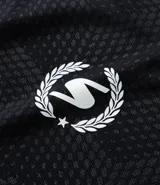 Remera deportiva negra con tecnología Dry, cuello redondo y manga corta. Presenta un estampado de patrón geométrico en relieve y logos blancos en el pecho.