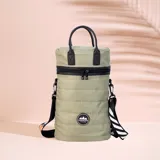 Matera estilo mochila color verde militar, confeccionada en nylon acolchado con detalles en símil cuero negro. Cuenta con tapa con cierre metálico, bolsillo interno, asas de mano y correa extensible para llevar al hombro o cruzada.
