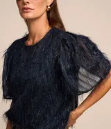 Blusa de chiffon azul marino con cuello redondo, mangas cortas con pliegues en los hombros y textura con felpas.