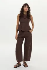 Top de lino marrón sin mangas, con cuello bote, corte ajustado en el torso y vuelo peplum en la cintura.