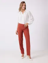 Pantalón sastrero de corte slim, color blanco, con pretina anatómica y panel interno modelador. Presenta bolsillos laterales tipo ojal, bolsillos traseros simulados y nervadura vertical marcada en el frente.