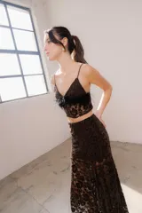 Pollera larga asimétrica confeccionada en encaje con detalles de terciopelo, con forro interno y cintura elástica.